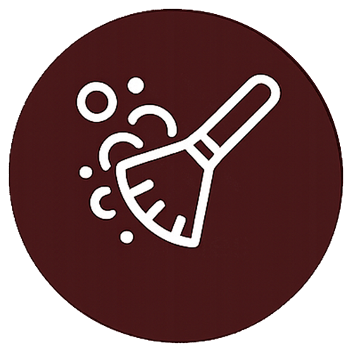 A person vacuums crumbs from a sofa cushion.